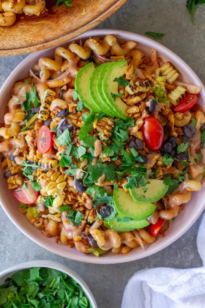 Vegan BBQ chicken pasta salad in a large bowl with crispy tofu, colorful vegetables, and creamy BBQ ranch dressing