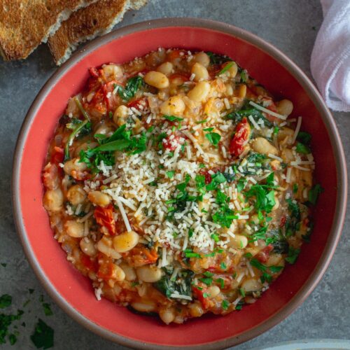 Finished creamy tuscan white bean skillet topped with parmesan and parsley