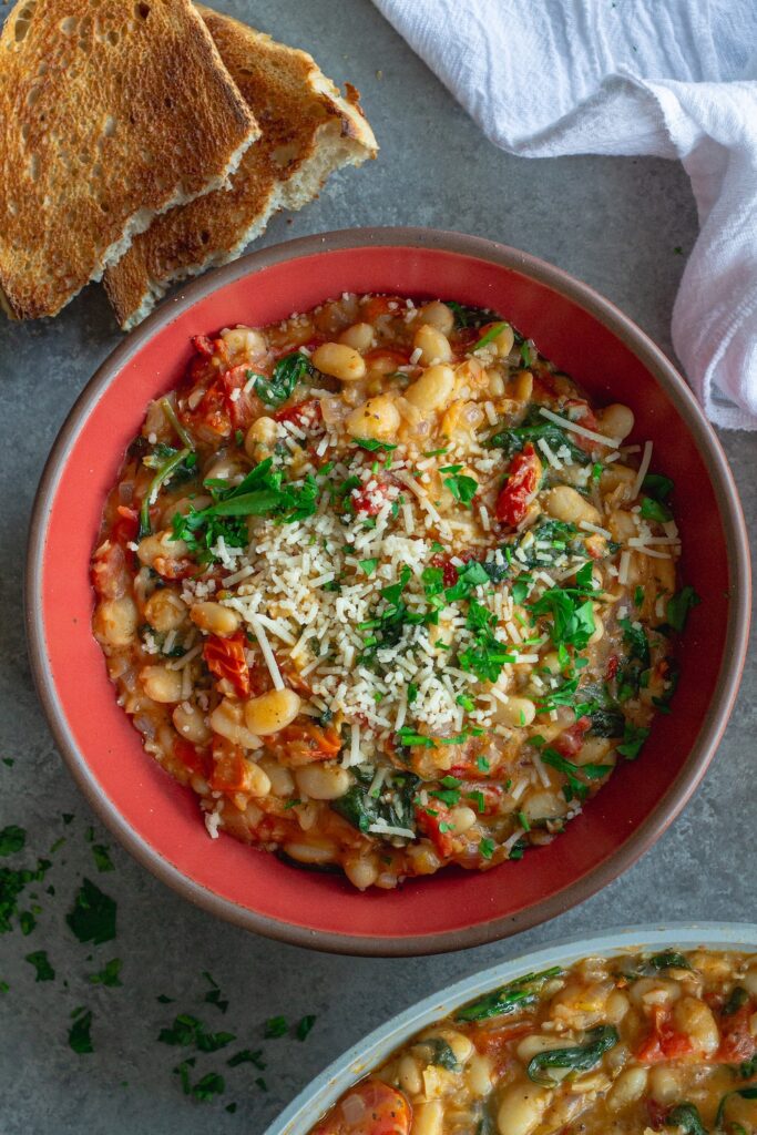 Finished creamy tuscan white bean skillet topped with parmesan and parsley