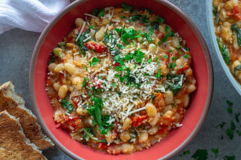Finished creamy tuscan white bean skillet topped with parmesan and parsley