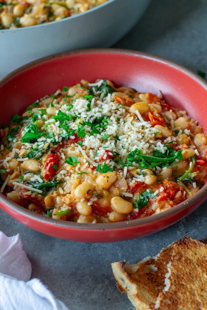Finished creamy tuscan white bean skillet topped with parmesan and parsley