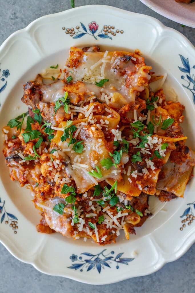 Vegan skillet lasagna served on a plate, showing the tender noodles mixed with the saucy filling, topped with melted vegan cheese and fresh parsley.