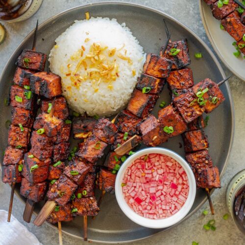 Filipino-style vegan BBQ tofu skewers glazed and charred, served with garlic rice and Filipino spiced vinegar