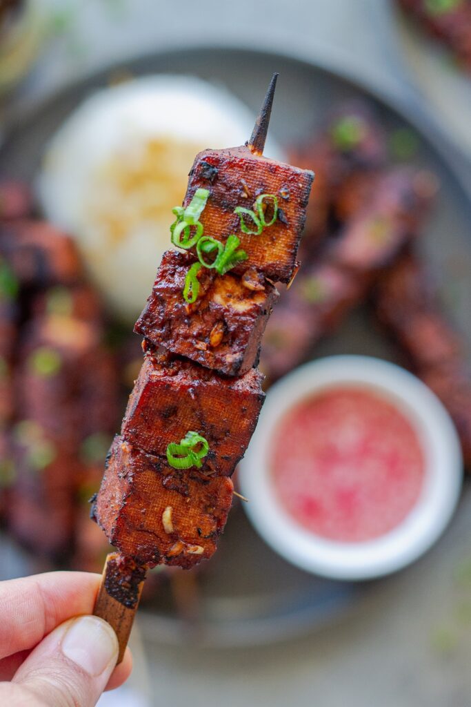 Filipino-style vegan BBQ tofu skewers glazed and charred, served with garlic rice and Filipino spiced vinegar