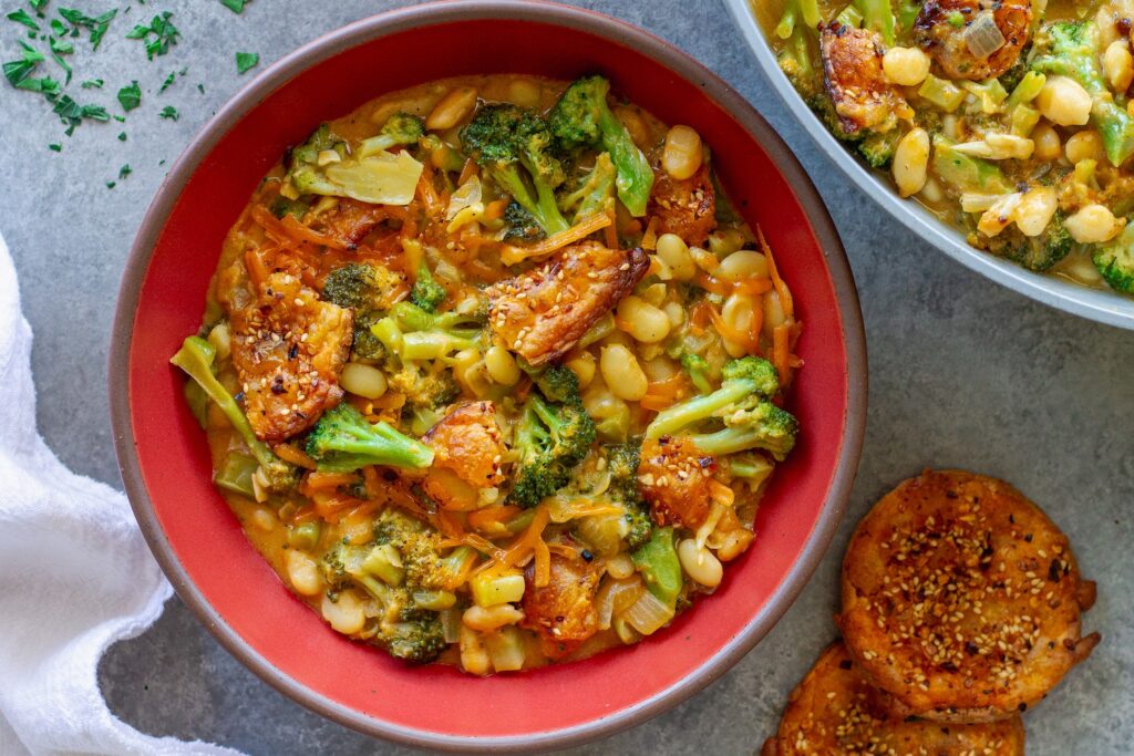 Creamy vegan skillet broccoli cheddar beans topped with golden cheese crisps