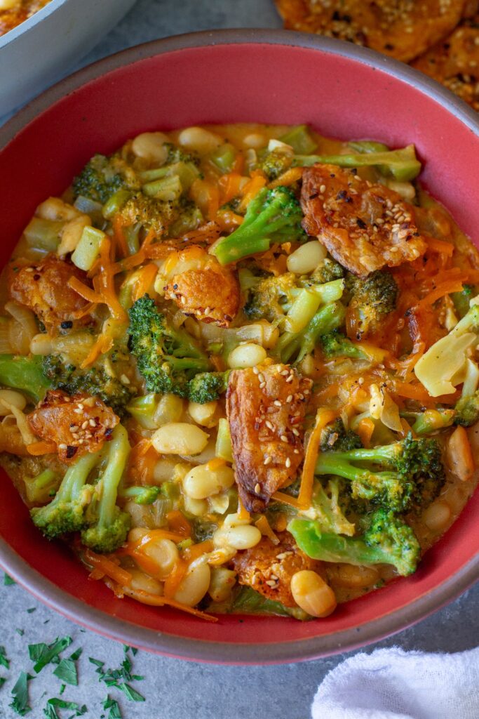 Creamy vegan skillet broccoli cheddar beans topped with golden cheese crisps