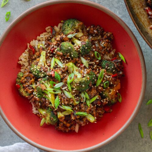 Broccoli tofu stir-fry served over rice with sesame seeds and green onion garnish