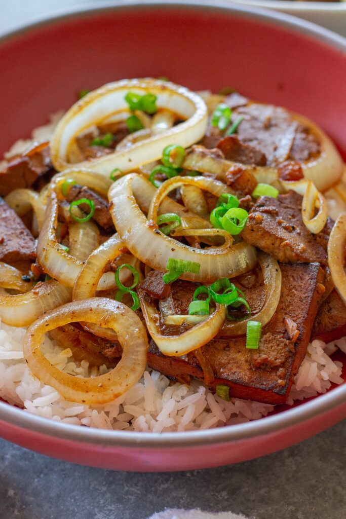 Vegan bistek tagalog with braised tofu and caramelized onion rings served over steamed rice.